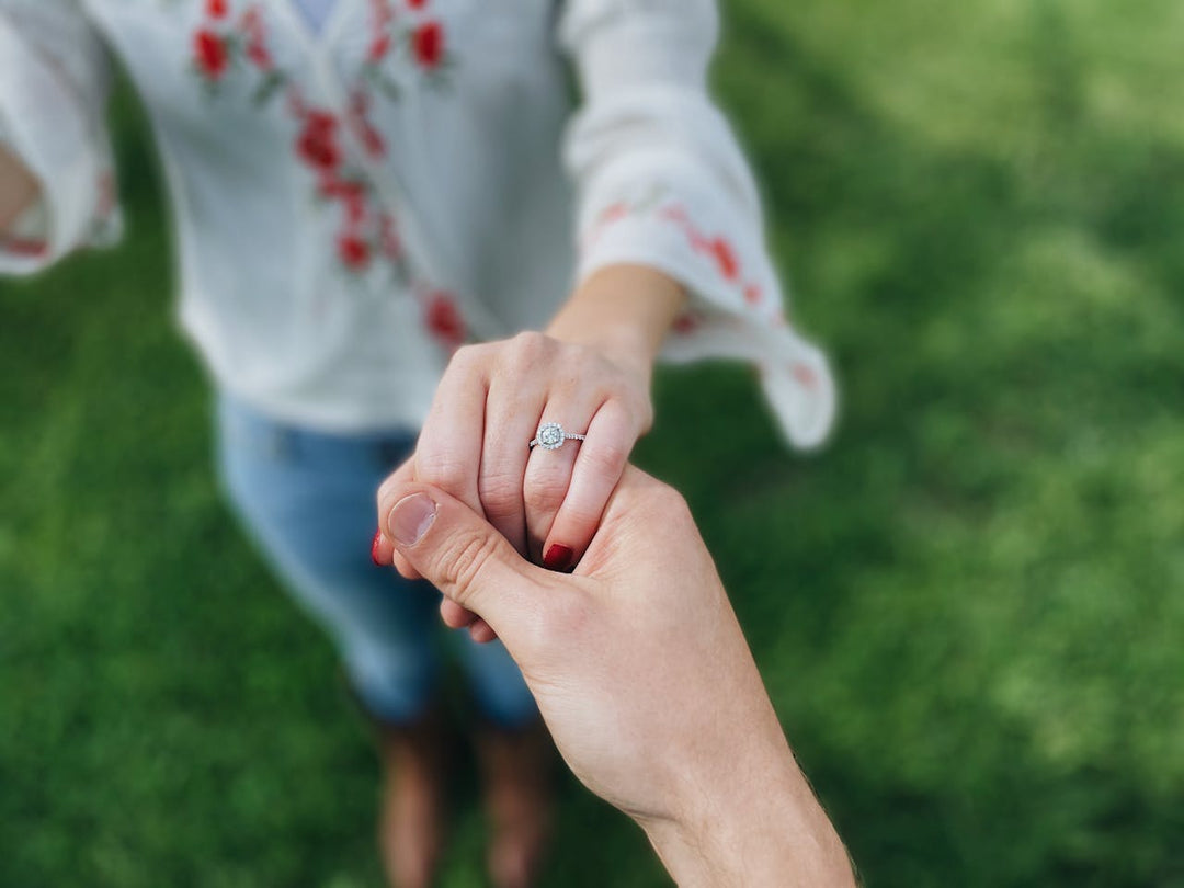 engaged couple with diamond engagement rings and holding hands
